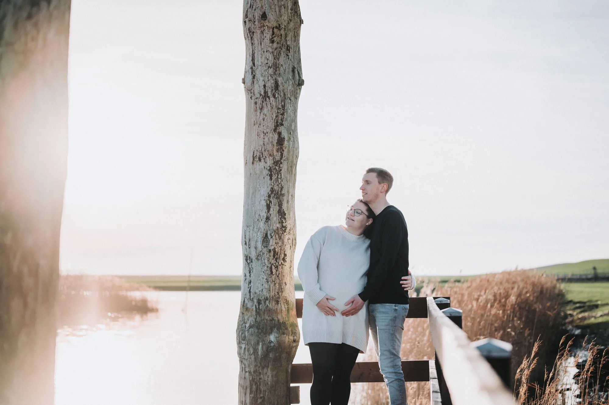 Werdende Eltern im Abendlicht am Wasser bei einem Babybauchshooting an der Nordsee
